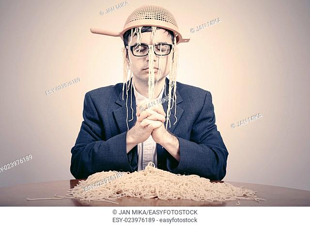 Pastafarian wearing a colander praying for pasta to the Flying Spaghetti Monster