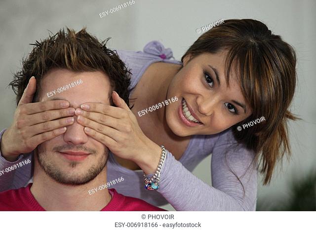 Woman covering boyfriend's eyes