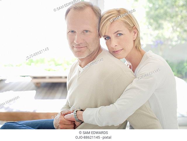 Couple hugging in living room