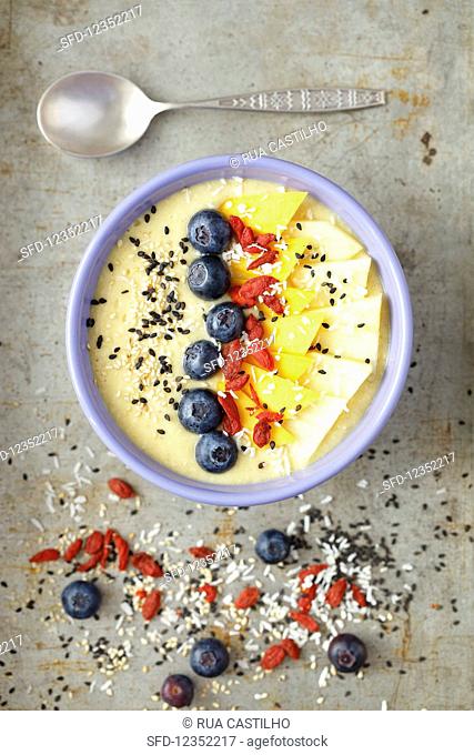 A tropical smoothie bowl with mango, pineapple, goji berries and coconut milk
