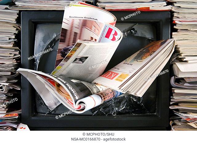 broken televiewer with newspapers