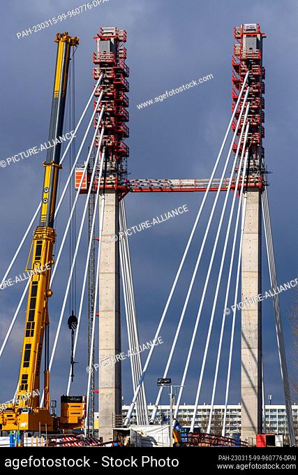 15 March 2023, Saxony-Anhalt, Magdeburg: A crane stands in front of the pylons of the new bridge construction in Magdeburg