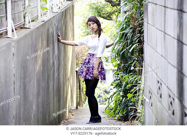 Japanese Girl poses on the street in Nakameguro, Japan. Nakameguro is a town located in the nice area of Tokyo