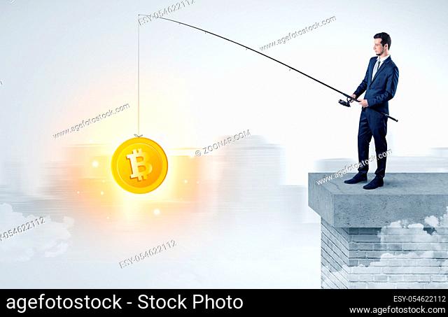 Young businessman fishing coins from a foggy city concept