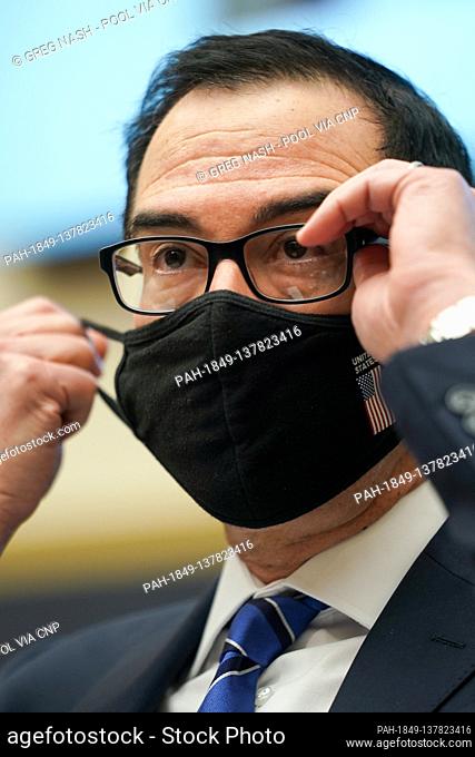United States Secretary of the Treasury Steven T. Mnuchin adjusts his mask during a House Financial Services Committee oversight hearing to discuss the Treasury...
