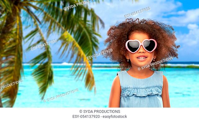 little african girl in sunglasses on beach