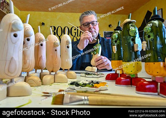 16 December 2022, Brandenburg, Freesdorf: Gerd Paegert, artist, painter and musician, makes the Spreewald gherkin as a smoking manikin in his small workshop...