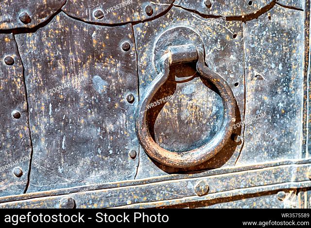 Antique cathedral metal door with doorknob made of iron