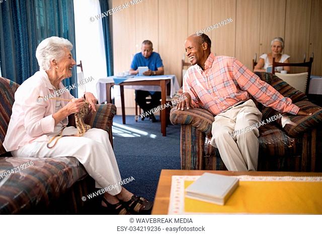 Cheerful senior man talking with woman