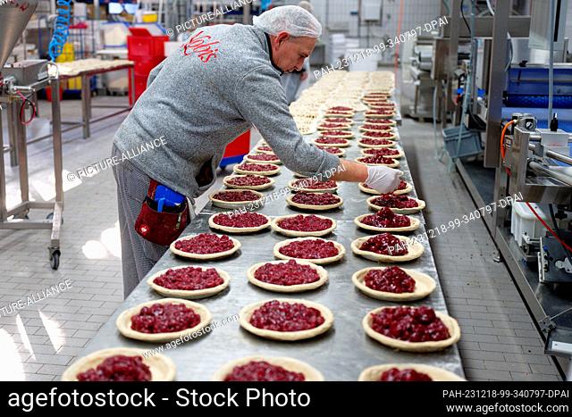 18 December 2023, North Rhine-Westphalia, Aachen: An employee works on cakes at the Nobis Printen bakery. Photo: Henning Kaiser/dpa