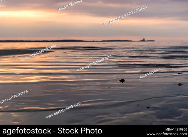 Light waves on the Baltic Sea at sunset on Laboe Beach, Germany