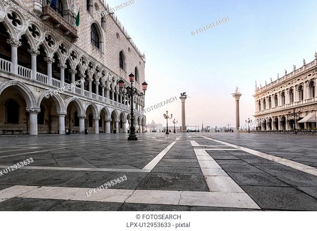 The Doge's Palace at dawn with empty Piazzetta, column with lion of San Marco, view to San Giorgio Maggiore beyond, Venice, Italy