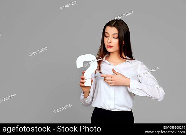 beautiful caucasian business woman with question mark on gray background