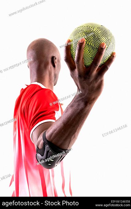 African american male athlete throwing ball while playing handball against white background