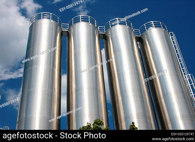 four round industrial tanks with blue sky as background  vier runde Industrietanks mit blauem Himmel als Hintergrund