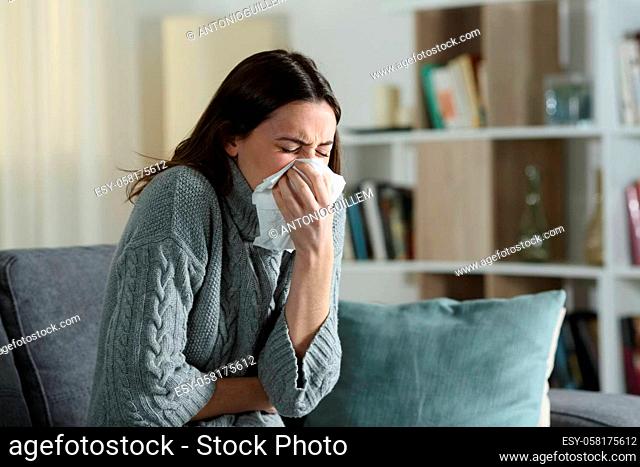 Woman suffering flu symptoms blowing on cloth