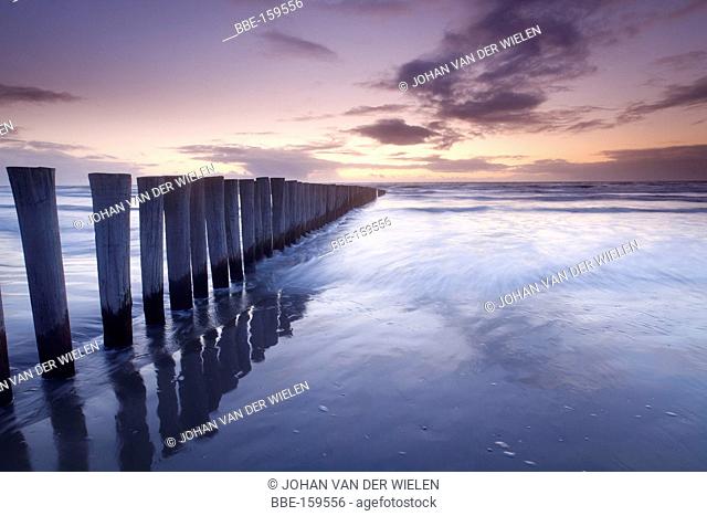 poles in the sea at sunset