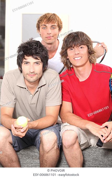 Three lads about to have a casual game of tennis