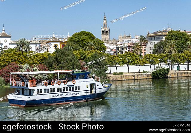 View over the river Rio Guadalquivir to the promenade with excursion boats and La Giralda, Sevilla, Andalusia, Spain, Europe