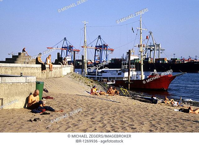 People at the beach of the Elbe river, in the back the historic ship museum Oevelgoenne, Elbe riverr and port of Hamburg, Hanseatic City of Hamburg, Germany