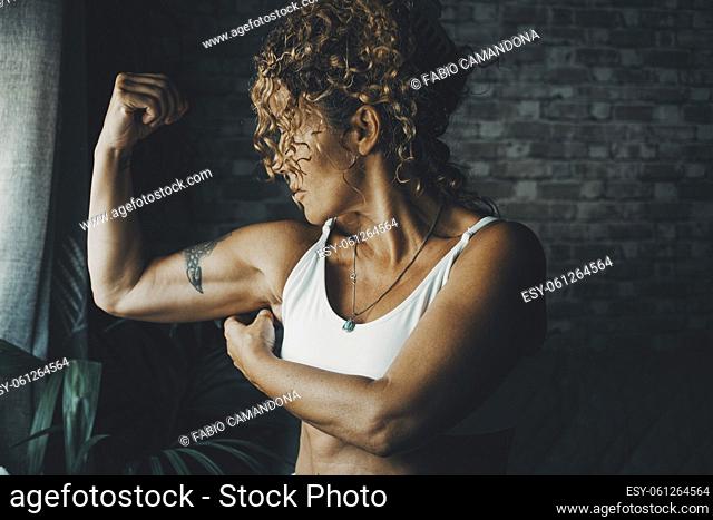 One middle age 50s woman at home doing biceps muscle. Concept of energy and power lady doing sport activity and fitness workout