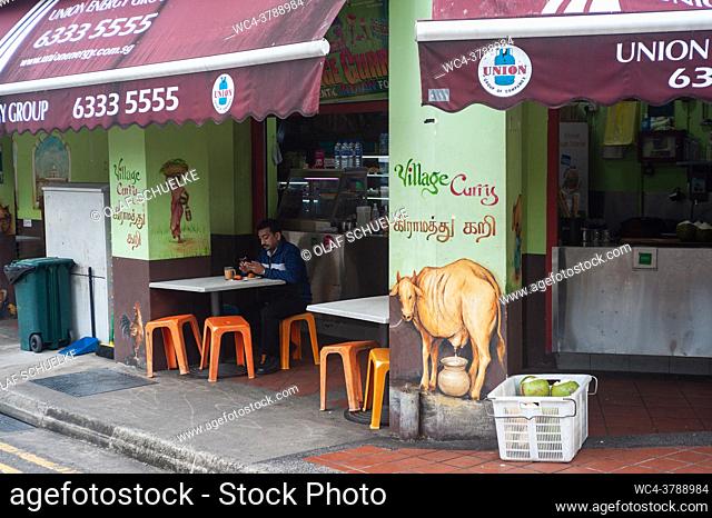 Singapore, Republic of Singapore, Asia - A man sits at the outdoor area of an Indian restaurant in Little India during the lasting coronavirus pandemic and...