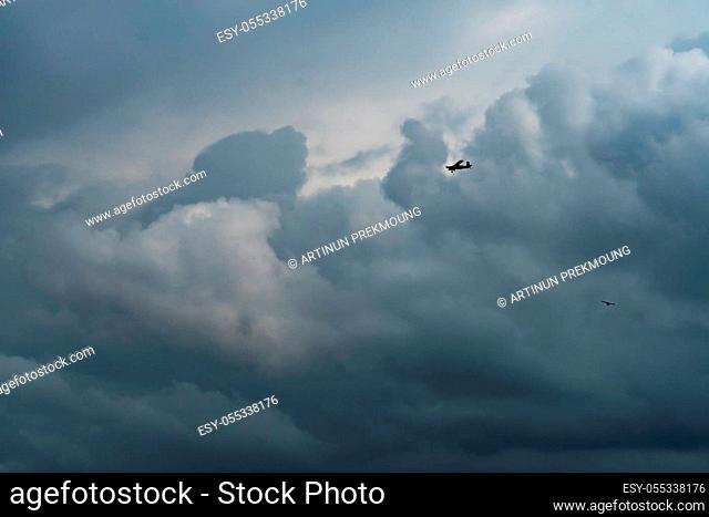 Small plane in cloudy sky for rainmaking. White fluffy clouds with small aircraft to make artificial rainfall. Two airplane flying on cloudy sky