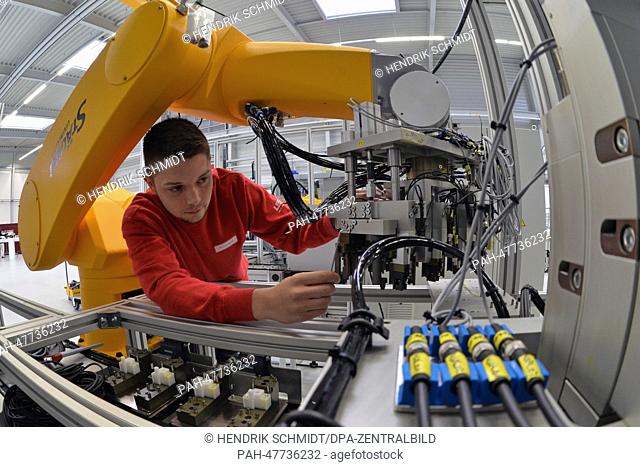 Industrial mechanic Kevin Landgraf installs the arm of a robot at the new site of the USK Karl Utz specialist equipment manufacturer in Limbach-Oberfrohna