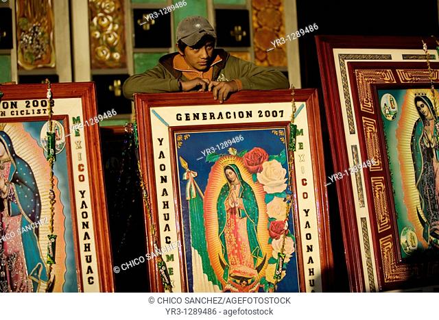 A teenager stands behind images of Our Lady of Guadalupe in Mexico City, December 10, 2010  Hundreds of thousands of Mexican pilgrims converged on the Our Lady...