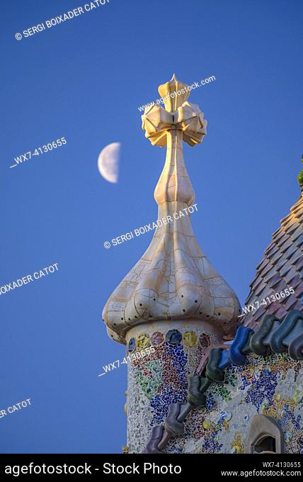 ENG: Sunrise over the roof of the Casa Batlló with the waning moon behind the cross of Saint George that crowns the façade (Barcelona, Catalonia, Spain)