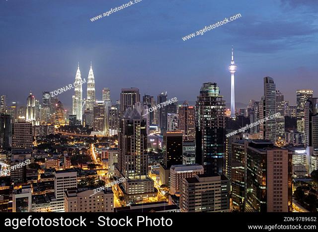 Night shot of Kuala. Panorama with city architecture and transport. Malaysia capital view with Petronas Towers and Menara Tower