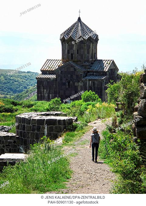 A visitor walks on a road leading towards the church of Surp Astvatsatsin (Holy Mother of God) in Ambed, Armenia, 28 June 2014