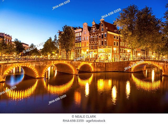 Illuminated bridges and reflections at night, Keizergracht and Leilesgracht canals, Amsterdam, North Holland, Netherlands, Europe