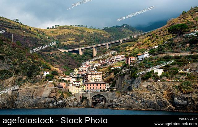 Village of Riomaggiore at the edge of a rocky cliff, Cinque Terre Liguria, Italy