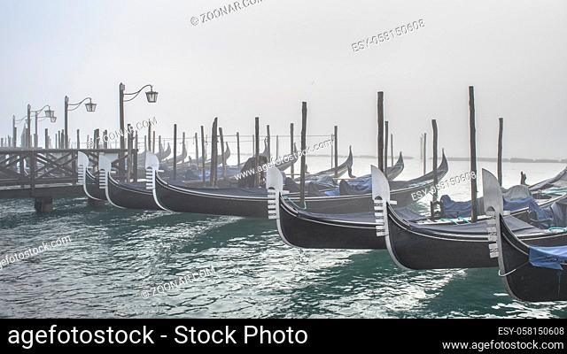 Winter morning scene group of gondolas parked at shore in venice city, Italy