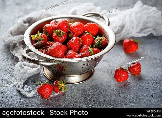 Fresh juicy appetizing strawberries in metal colander
