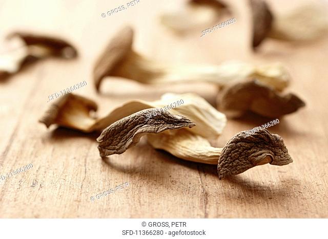 Dried king trumpet mushrooms on a wooden surface