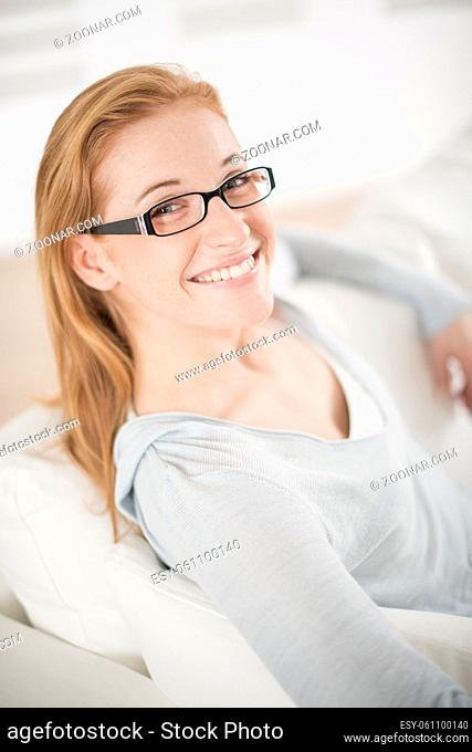 a beautiful smiling redhead woman on the couch