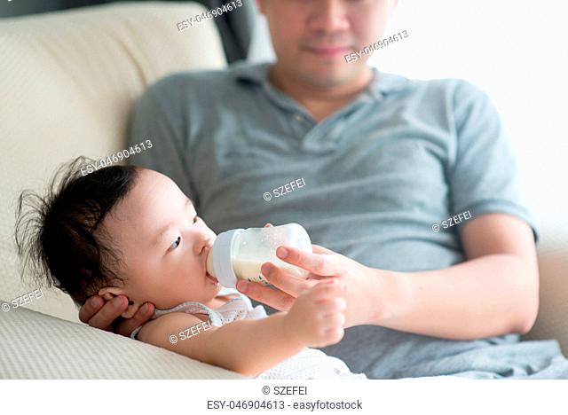 Father bottle feed milk to child
