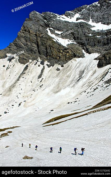 Alpinisten überqueren ein Schneefeld im Salentse Kar auf dem Weg zur Rambert Hütte, Grand Muveran Massiv hinten, Ovronnaz, Wallis