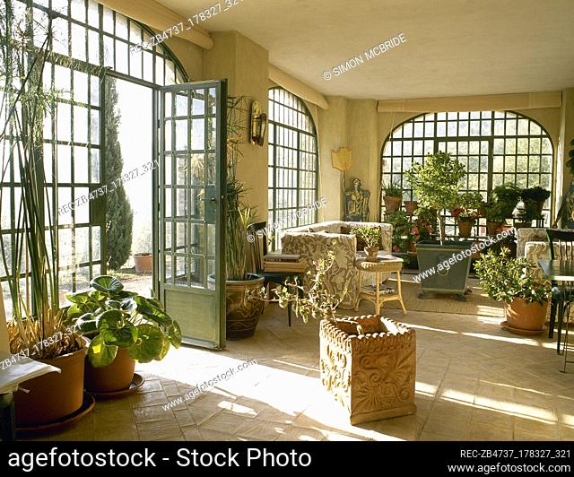 Country style conservatory garden room with tiled floor and sunlight through windows