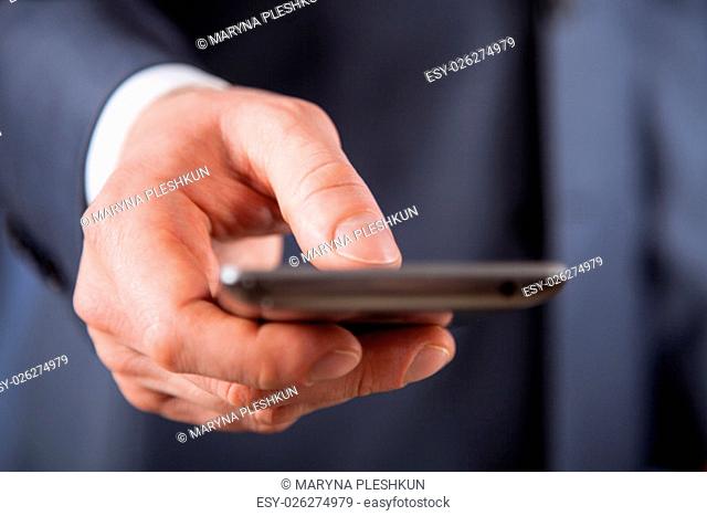 Unrecognizable businessman holding a cellphone, closeup shot