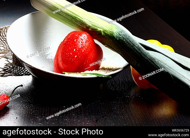 Healthy fresh organic food with water drops with rice and red and yellow pepperoni and green leek