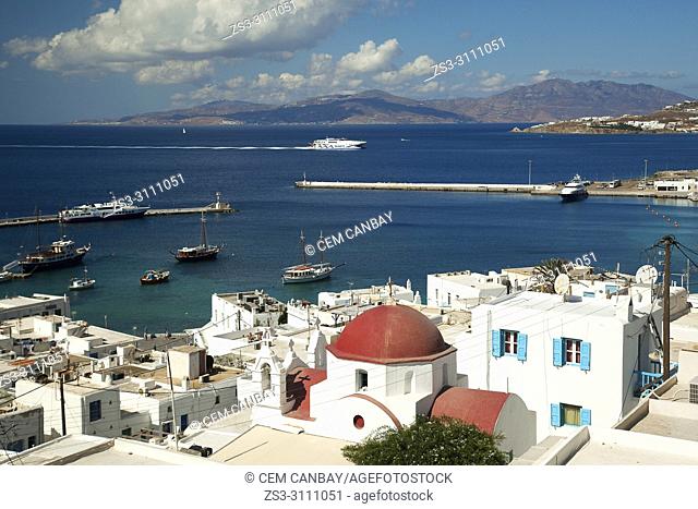 View to a red domed church in town center with a speed ferry entering the harbour at the background, Mykonos, Cyclades Islands, Greek Islands, Greece, Europe
