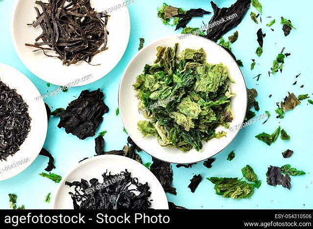 Dry seaweed, sea vegetables, top shot on a light blue background
