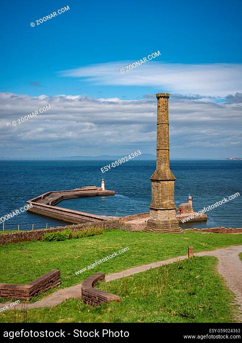 The Candlestick Chimney with the pier and the West Pier Lighthouse in the background, seen in Whitehaven, Cumbria, England, UK