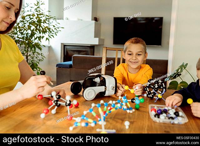 Smiling boy looking at DNA model on table
