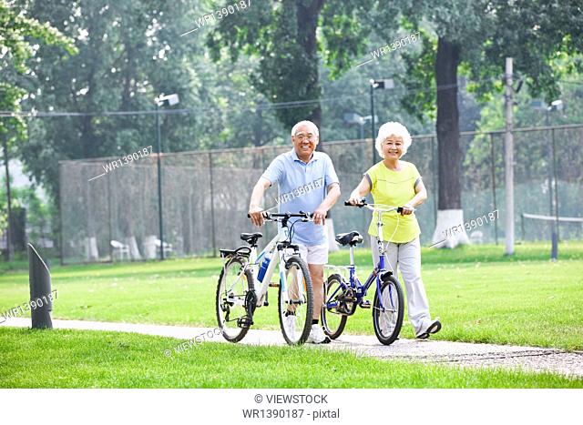 Happy elderly couple riding a bicycle