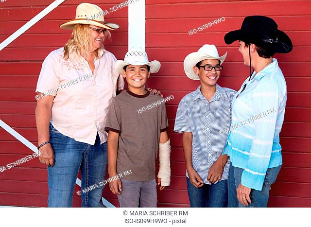 Family of four standing by barn