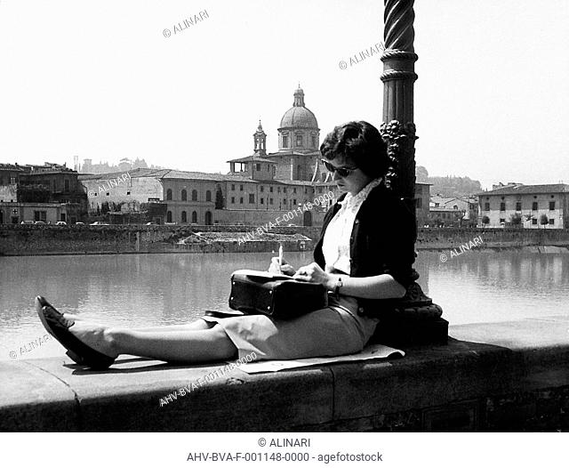 Young woman sitting on the lungarni in Florence (1680-1689), shot 1960 ca. by Balocchi Vincenzo